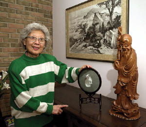 A women standing next to asian artifacts